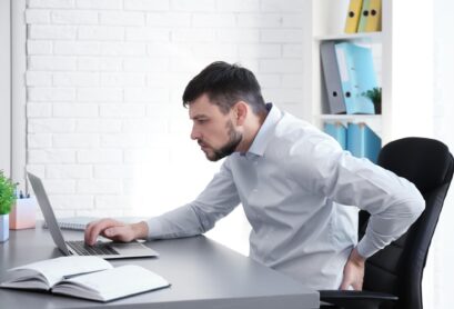 posture-concept-man-suffering-from-back-pain-while-working-with-laptop-office