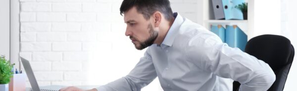posture-concept-man-suffering-from-back-pain-while-working-with-laptop-office